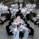Bride and groom embracing in a luxury wedding venue with crystal chandeliers