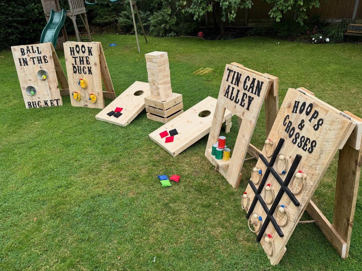 Wooden outdoor lawn games arranged on a green grass field for a celebration.