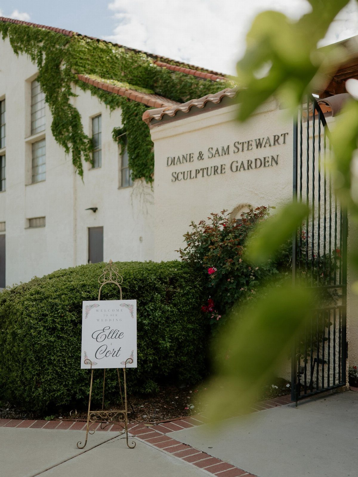 Wedding welcome sign on a gold easel outside the Stewart Sculpture Garden entrance