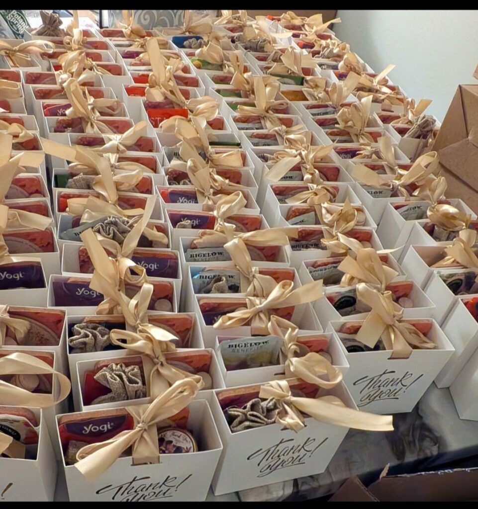 White thank you favor boxes with gold ribbons containing tea and treats.